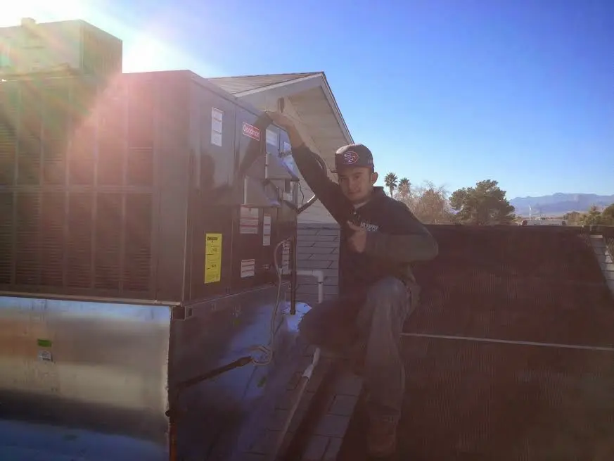 HVAC technician performing AC Tune-Up on a rooftop unit in Hattiesburg